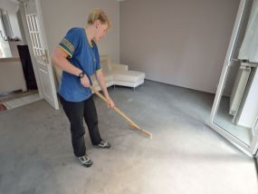 Mittels eines speziellen Teppichbesens richtet unsrer Mitarbeiterin den Flor des gereinigten Teppichbodens wieder auf.