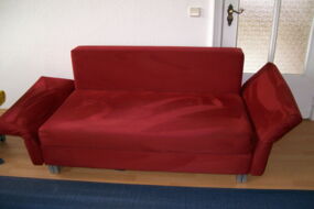 Hier sehen Sie eine saubere Schlafcouch, welche mit weinrotem Alcantara bezogen ist. Das Schlafsofa sieht nahc unserer Polsterreinigung aus, als ob es neu wäre.